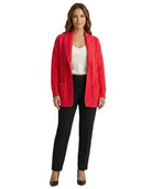 Woman wearing a red cardigan over a white top and black pants on a white background