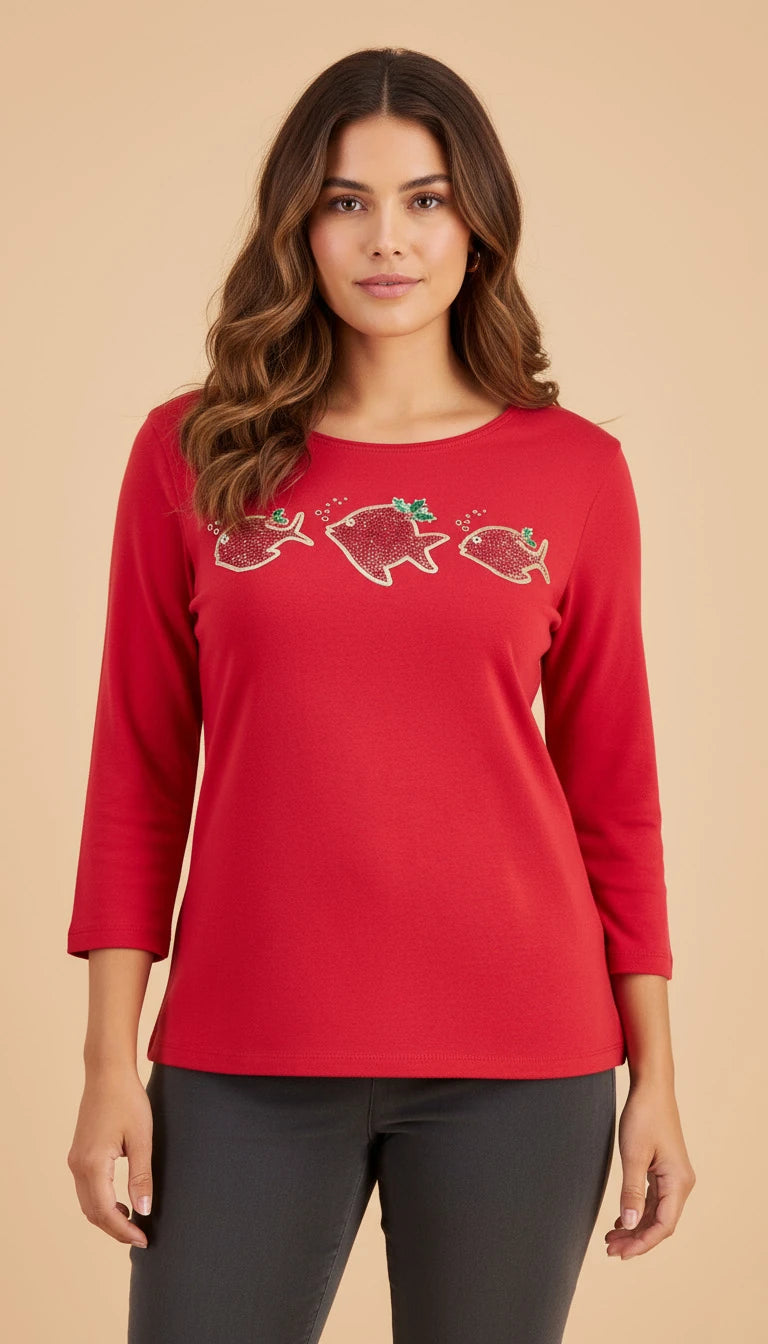 Woman wearing a red long-sleeve top with fish designs on a beige background