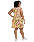 Woman wearing a yellow floral dress on a white background