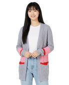 Woman wearing a gray cardigan with pink accents on a white background